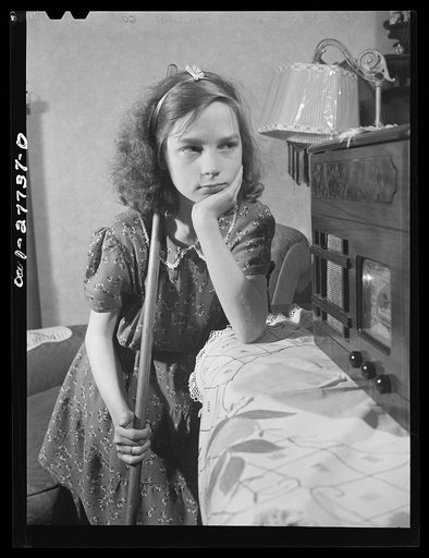 Buffalo, New York. Beverly Ann Grimm, eleven, the oldest of six children, stops to listen to the radio while sweeping the front room. Her mother, a twenty-six year old widow, is a crane operator at Pratt and Letchworth