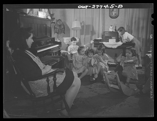 Buffalo, New York. The Grimm family sitting in the living room after supper on a Sunday evening. Mrs. Grimm, a twenty-six year old widow, is a crane operator at Pratt and Letchworth. The two youngest children live in a foster home during the week