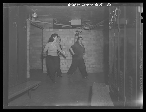 Bell Aircraft Corporation, Niagara Falls, New York. Women employees rushing for their coats in the women's locker room at 4 p.m. They hurry in order not to have to stand on the buses