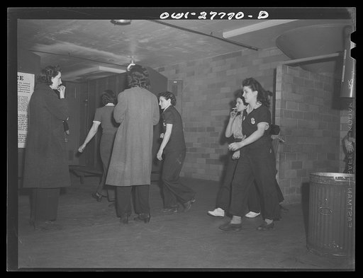 Untitled photo, possibly related to: Bell Aircraft Corporation, Niagara Falls, New York. Women employees rushing for their coats in the women's locker room at 4 p.m. They hurry in order not to have to stand on the buses
