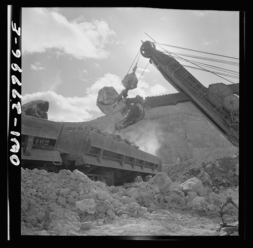 Untitled photo, possibly related to: Morenci, Arizona. A huge electric shovel at an open-pit copper mine loading an ore train on its way to the smelter plant of the Phelps Dodge mining corporation