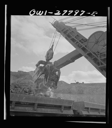 Untitled photo, possibly related to: Morenci, Arizona. A huge electric shovel at an open-pit copper mine loading an ore train on its way to the smelter plant of the Phelps Dodge mining corporation
