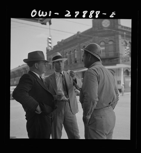 Orange, Texas. Shipyard worker talking with two friends