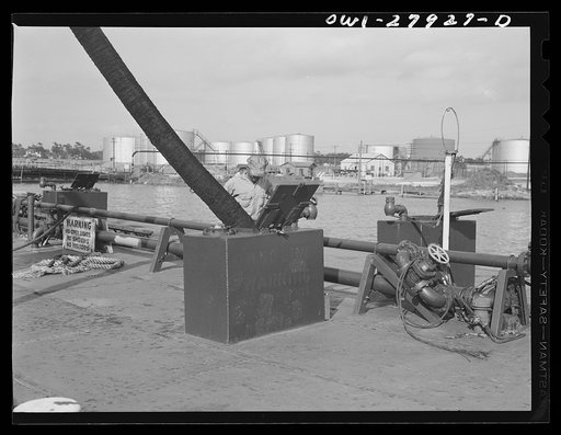 Loading a barge with oil at a refinery. Baytown, Texas