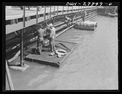Baytown, Texas. Turning the valve at a refinery which sends oil into the hold of a barge