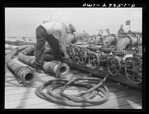 Baytown, Texas. Turning the valve at a refinery which sends oil into the hold of the barge