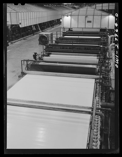 Untitled photo, possibly related to: Houston, Texas. Dry end of a Kraft paper making machine at the Champion paper company. The paper is cut into square sheets as it comes out this end of machine
