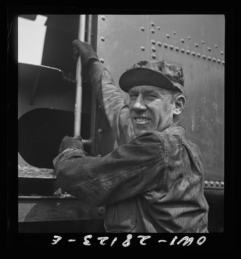 An American soldier engineer climbing into the cab of his train. An engineer in private life, he is happy at the chance to push supplies in the aid to Russia drive. Somewhere in Iran
