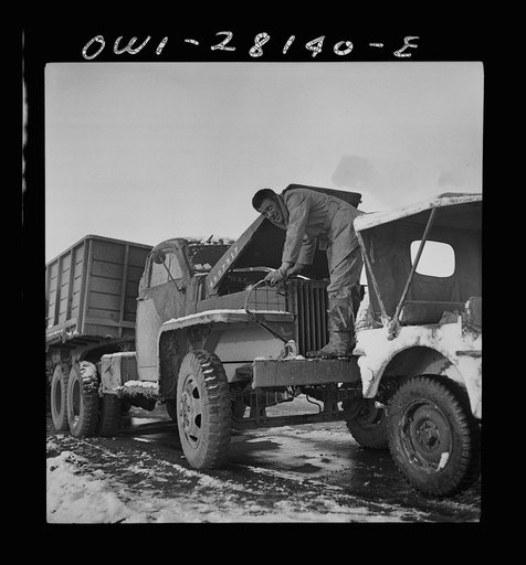 A truck driver checking the oil. He is with a United States Army truck convoy carrying supplies for the aid of Russia. Somewhere in the Persian corridor