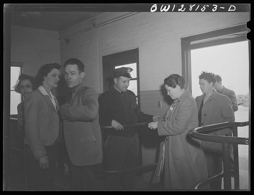 Untitled photo, possibly related to: Niagara Falls, New York. All workers must show their badges and insides of their lunch boxes and packages to the guards at the gate when they enter and leave the Bell Aircraft plant