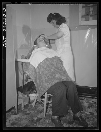 Buffalo, New York. Mrs. Grimm, a twenty-six year old widow with six children who is a crane operator at Pratt and Letchworth, having her hair done after work
