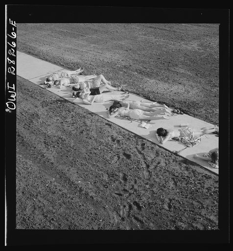 Arlington Farms, war duration residence halls. Sunbathers on the sidewalk in the back of Idaho Hall at Arlington Farms