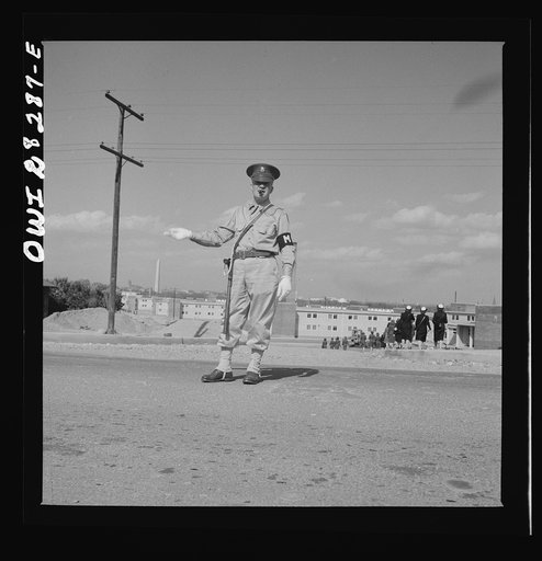 Arlington Farms, war duration residence halls. Military Police acting as traffic officer by the bus stop at Arlington Farms