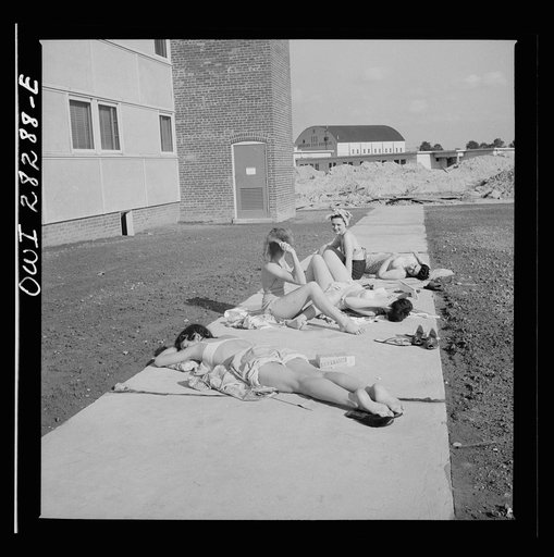 Arlington Farms, war duration residence halls. Sunbathers on the sidewalk in the back of Idaho Hall at Arlington Farms