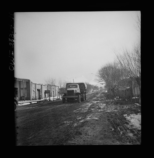 Somewhere in the Persian corridor. A United States Army truck convoy carrying supplies for the aid of Russia. The convoy passing through a Persian village