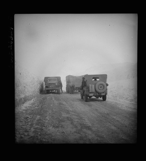 Somewhere in the Persian corridor with a United States convoy carrying supplies for the aid of Russia. Having a bad moment on the snowbound mountain pass as the American trucks ease by a disabled truck