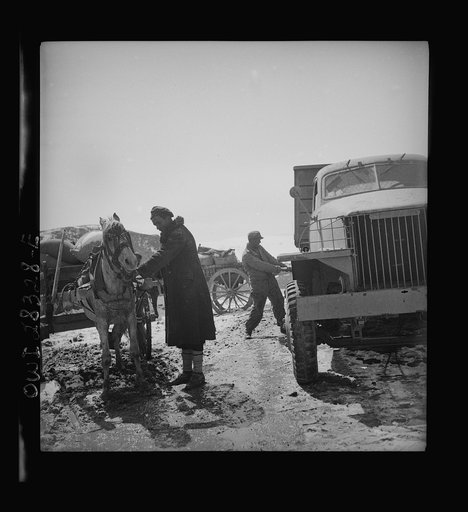 Somewhere in the Persian corridor. A United States Army truck convoy carrying supplies for the aid of Russia. Tightening the loads to the carriers before entering a dangerous, snowbound mountain pass