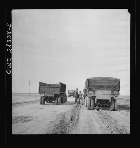 Somewhere in the Persian corridor. A United States Army truck convoy carrying supplies for Russia, moving by a disabled truck. This truck will be repaired by a crew of mechanics riding at the end of the convoy