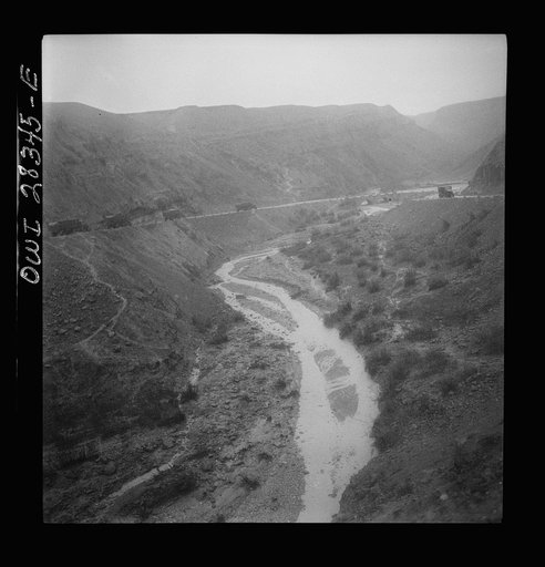 Somewhere in the Persian corridor. A United States Army truck convoy carrying supplies for Russia winding around a gorge in the mountain pass