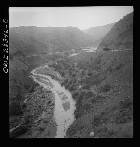 Somewhere in the Persian corridor. A United States Army truck convoy carrying supplies for Russia winding around a gorge in the mountain pass