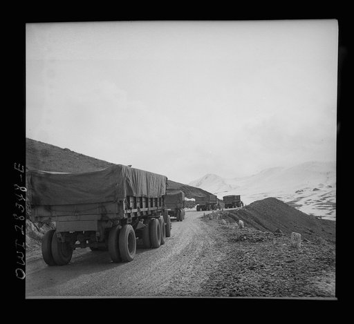 Somewhere in the Persian corridor. A United States Army truck convoy carrying supplies for Russia climbing a mountain road