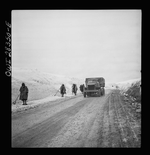 Somewhere in the Persian corridor. A United States Army truck convoy carrying supplies for Russia climbing a snowbound mountain pass being cleared by Iranian road workers who are fighting to keep the road open