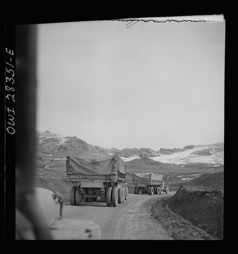 A United States Army truck convoy carrying supplies for Russia climbing a snowbound mountain pass somewhere in the Persian corridor. Iranian road workers struggle to keep the pass open