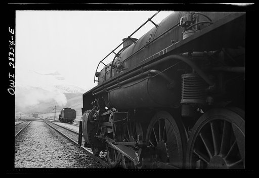 An American engine pulling a great load of supplies for Russia along a mountain- rimmed plateau somewhere in Iran