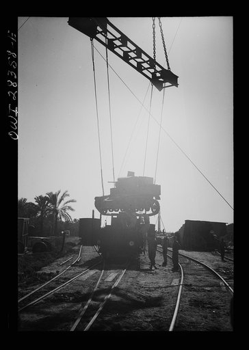 An American tank being loaded onto a railroad car in the Middle East enroute to Russia
