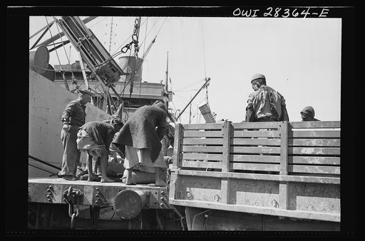 Ship to railroad car to truck--no time is lost moving supplies for Russia from a Liberty ship to a railroad car to a truck somewhere in the Middle East