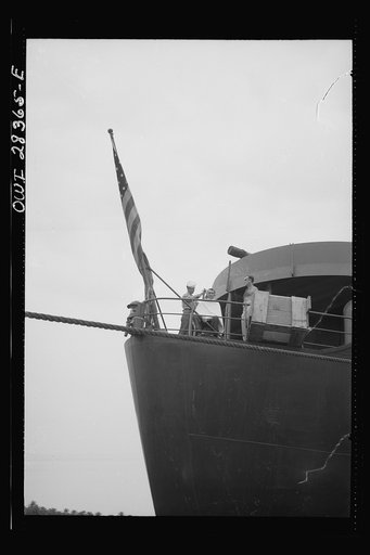 American seaman giving a haircut to a fellow member of the crew as they pull in to unload their freight which is destined for Russia somewhere in the Middle East