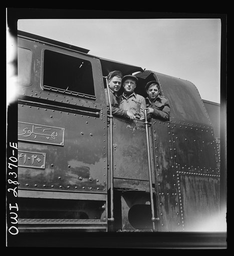 American, Russian and English engineers in the cab of an engine. Each of them has done his part in hurrying supplies enroute to Russia along a railroad in Iran