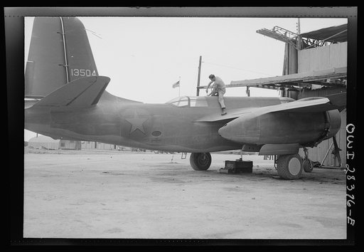 American airplane mechanic putting finishing touches to a warplane before delivery to the Russians. Somewhere in Iran