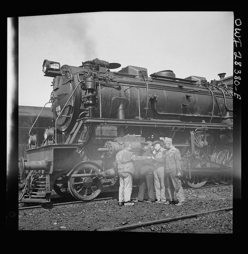American and Russian railroad engineers are examining one of the German-made engines which are used to haul supplies to Russia in Iran