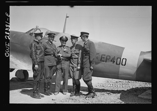 Somewhere in Iran. Major General Lewis Brererton in the center, the Commander of the United States Army force in the Middle East, with a group of Russian officers standing before an American warplane delivered to the Russians. A United States warplane is being tested in the background and bears the 