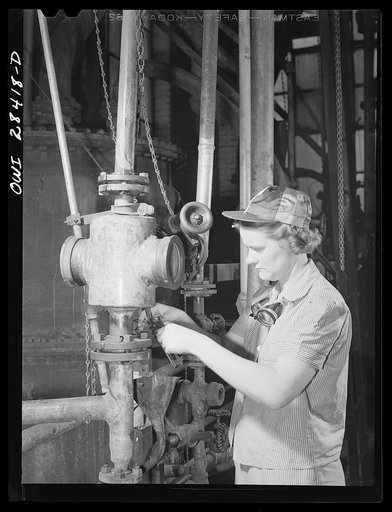 Niagara Falls, New York. Nan Hannegan, a nineteen year old chemical operator at the Niacet chemical company, earning thity-nine dollars a week, taking a sample of acid from a still. She will put in brine to bring it to a freezing point