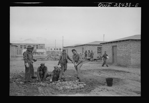 Repairing the road around the billets of American troops who will work at the railroad yard where supplies for Russia pass. Somewhere in Iran