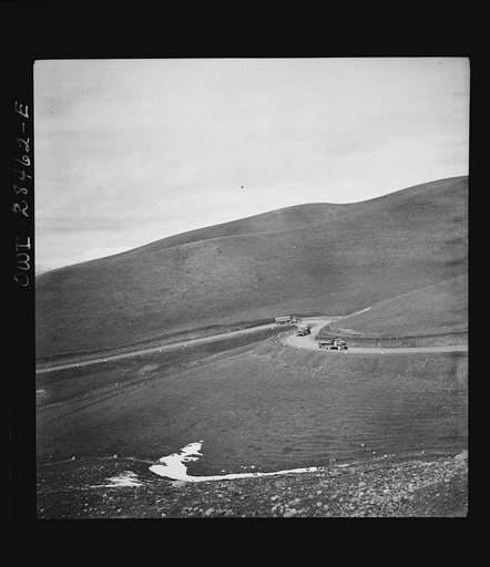 Somewhere in the Persian corridor. A United States Army truck convoy carrying supplies for Russia climbing a winding mountain road