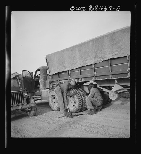 Somewhere in the Persian corridor. A United States Army truck convoy carrying supplies for Russia stopping to check trucks and for the drivers to have a smoke on the desert