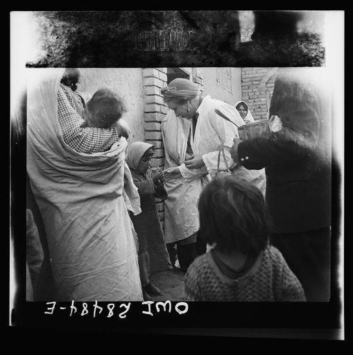 Teheran, Iran. Mrs. Louis Dreyfus, wife of the United States Minister to Iran, distributing food in the poorer section of the city