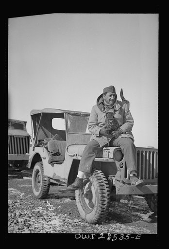 Somewhere in the Persian corridor. A United States Army truck convoy carrying supplies for Russia. OWI (Office of War Information) photographer Nick Parrino on the jeep which he rode in making a photographic record of the first run by an all-American convoy