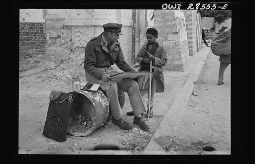 Lieutenant Milton Marx of New York City, attached to the Public Relations Office of the United States Army Ninth Air Force, does some painting in the streets of Tripoli. In civilian life Marx is a commercial artist