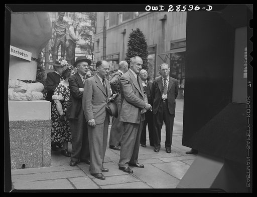 New York, New York. Interested spectators attracted by the exhibits at the Nature of the Enemy show, put up by the United States OWI (Office of War Information) at Rockefeller Plaza