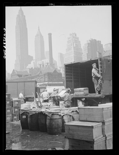 New York, New York. Dock workers loading boxes of fish onto trucks for shipping to retailers