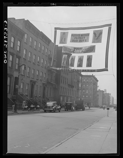 New York, New York. Street scene, with war effort poster by Sacred Heart Parish