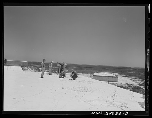 Freeport Sulphur Company, Hoskins Mound, Texas. Blasting crew on top of a sulphur vat preparing to dynamite it