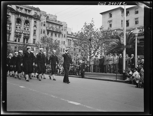 Field Marshall Smuts, Prime Minister of the Union South Africa, receives salute from Lieutenant Bergman, United States Navy, heading a group of U.S. Navy men passing in review in the Navy Week Celebration parade in Johannesburg. Also on the stand are Rear Admiral R.J.R. Scott (at Smutt's right), dir