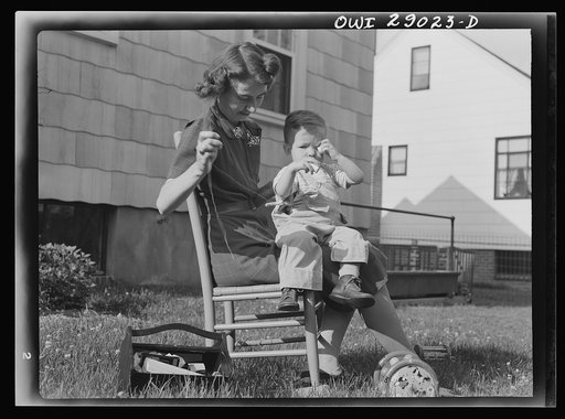 Untitled photo, possibly related to: A mother sewing a button on her child's overalls. Silver Spring, Maryland