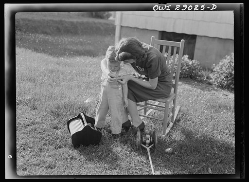 Untitled photo, possibly related to: A mother sewing a button on her child's overalls. Silver Spring, Maryland