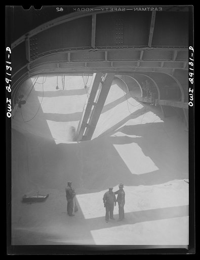 Buffalo, New York. Half-empty hold of a grain boat from Deluth unloading wheat at a grain elevator on the Erie Canal. In middle ground is the "leg" which draws grain into the tower by means of an endless belt of buckets